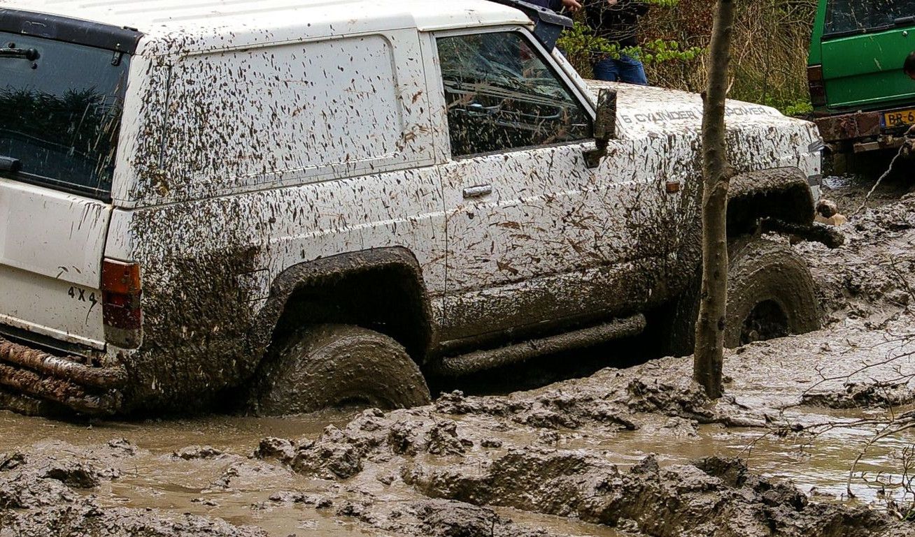 Nissan vehicles engaged in challenging off-road mud adventure in Stadtoldendorf, Germany.